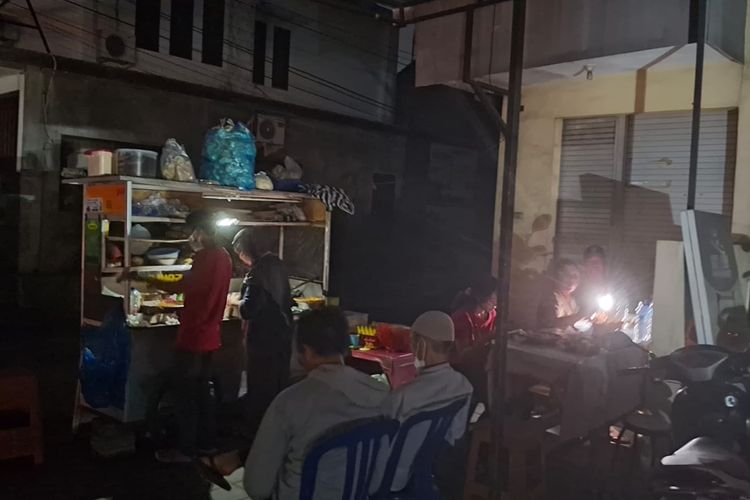Pedagang di Bali menggunakan senter ponsel dan lilin untuk penerangan karena listrik padam, Jumat (2/5/2025)