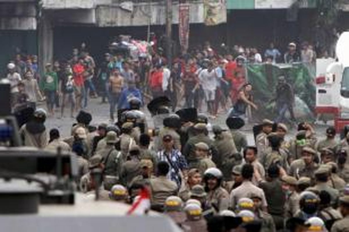 Warga Kampung Pulo, Jakarta Timur, terlibat kerusuhan dengan Satpol PP dan polisi di Jalan Jatinegara Barat, Kamis (20/8/2015). Kerusuhan terjadi karena warga menolak digusur dan dipindahkan untuk normalisasi Kali Ciliwung.