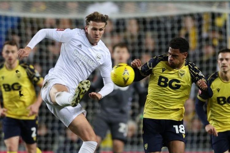 Bek Arsenal, Rob Holding (kir), berebut bola dengan pemain Oxford United, Marcus McGuane, dalam pertandingan putaran keempat Piala FA 2022-2023 yang digelar di Stadion Kassam, Oxford, pada Senin (9/1/2023) malam waktu setempat.