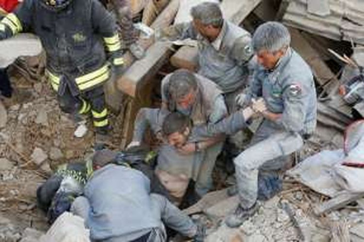  Seorang pria diselamatkan dari timbunan puing bangunan yang roboh akibat gempa pada Rabu (24/8/2016) dini hari di Amatrice, Italia tengah.