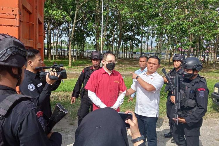 Tersangka kasus dugaan judi online, Apin BK diapit penyidik Polda Sumut saat penyerahan berkas, tersangka dan barang bukti kasusnya kepada Kejaksaan Tinggi Sumatera Utara pada Kamis (26/1/2023) sore.