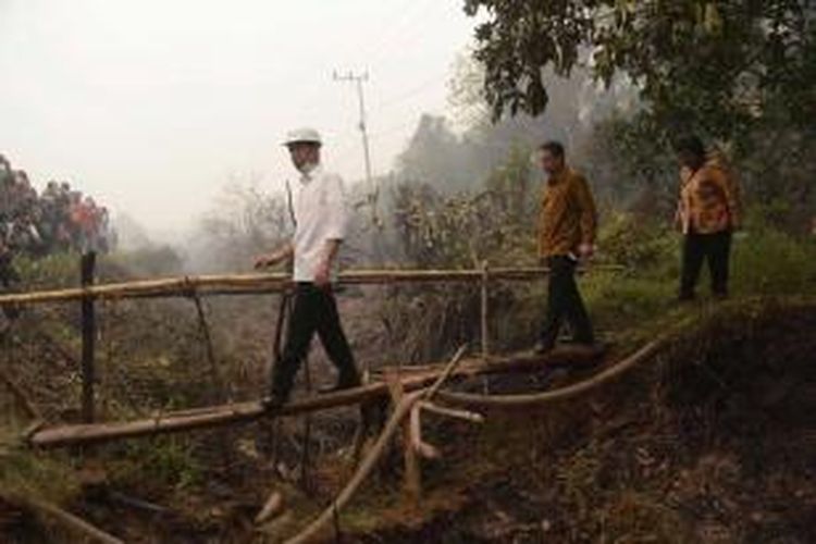 Presiden Joko Widodo (kiri) bersama Kepala BNPB Willem Rampangilei (tengah), dan Menteri Kehutanan dan Lingkungan Hidup Siti Nurbaya, saat melakukan inspeksi kebakaran hutan gambut di Kabupaten Kapuas, Kalimatan Tengah, 24 September 2015.
