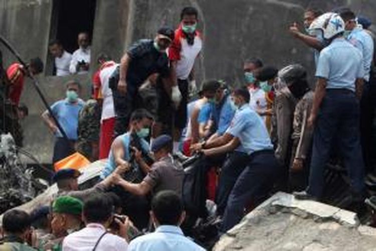 Tim penolong membawa seorang korban jatuhnya pesawat Hercules C-130 TNI AU di Jalan Jamin Ginting, Medan, Sumatera Utara, 30 Juni 2015. Pesawat itu jatuh dua menit setelah lepas landas dari Pangkalan Udara Soewondo pada pukul 12.08 WIB ketika hendak menuju Tanjung Pinang.