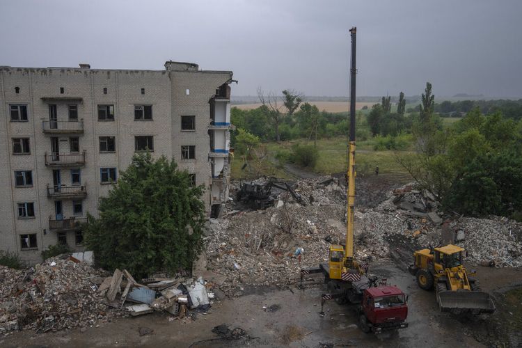 Pekerja darurat Ukraina bekerja untuk menarik orang keluar dari puing-puing setelah serangan roket Rusia menabrak gedung apartemen, di Chasiv Yar, wilayah Donetsk, Ukraina timur, Senin, 11 Juli 2022.