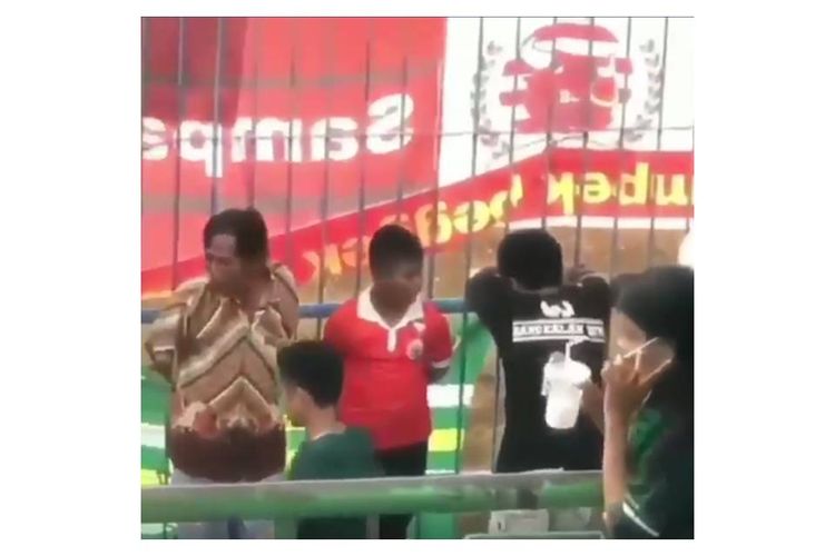 Tangkapan layar dari sebuah video yang memperlihatkan seorang bocah memakai jersey Persija Jakarta saat menonton pertandingan antara Persebaya Surabaya melawan Madura United.