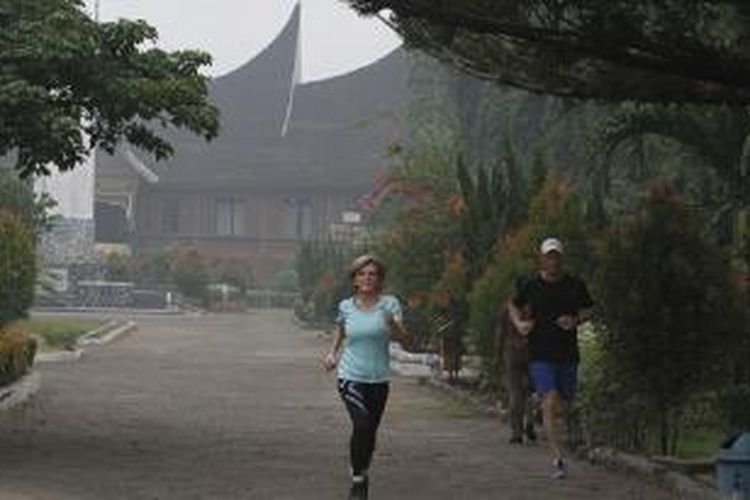 Menteri Luar Negeri Australia Julie Bishop (59 tahun) terlihat berlari di tengah kabut asap yang mulai menyelimuti Sumatera Barat, Jumat (23/10/2015).