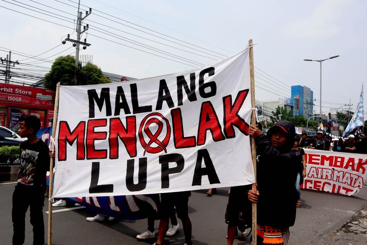 Suporter Arema, Aremania dan masyarakat melakukan aksi damai dengan membawa spanduk terkait Tragedi Kanjuruhan yang dilaksanakan di sejumlah titik Kota Malang, Minggu (04/12/2022) siang.