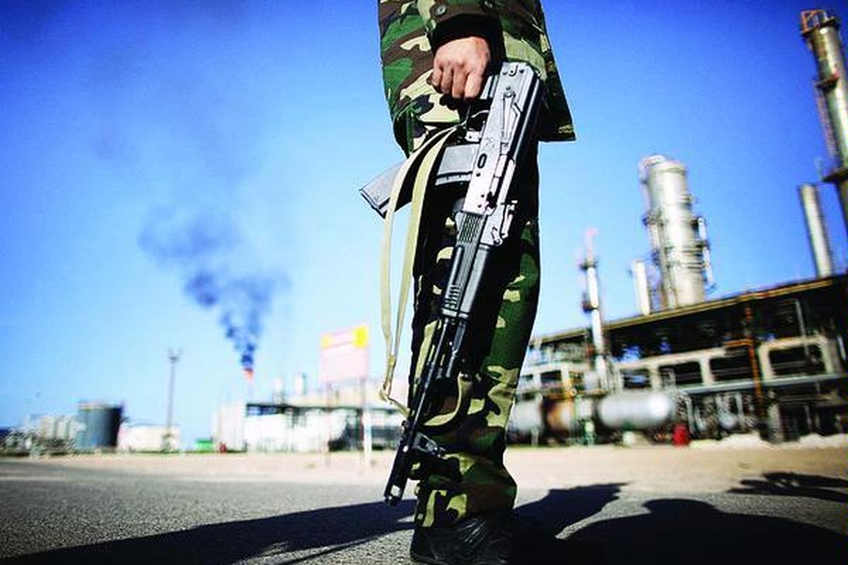 Seorang tentara  Dewan Transisi Nasional (NTC) berjaga di kompleks pengilangan minyak Zawiya, sekitar 40 kilometer sebelah barat Tripoli, Kamis (27/10). Kompleks pengilangan minyak yang dibangun dua tahap, tahun 1974 dan 1976, itu mengolah minyak mentah dari tambang minyak di gurun dengan kapasitas 120.000 ton minyak mentah setiap hari.