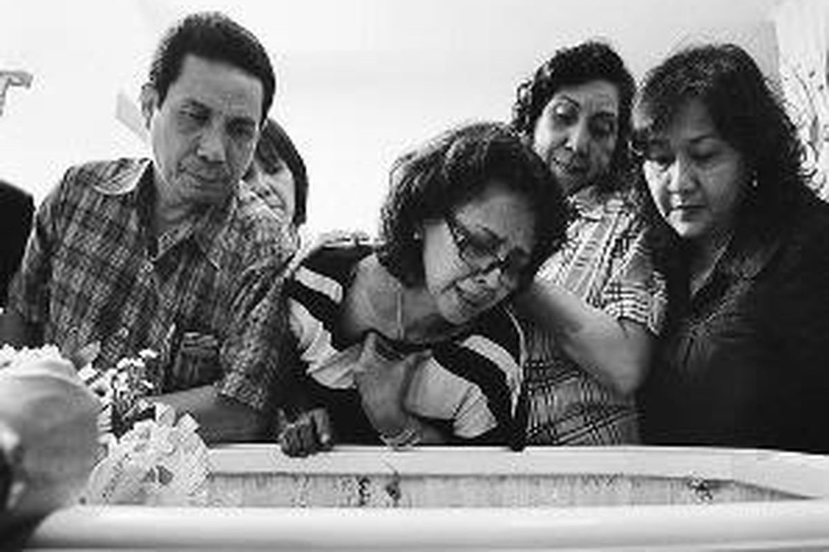 Stella (kedua dari kiri), istri Ronny Pattinasarany, didampingi kerabatnya menatap sedih jenazah mantan pemain sepak bola terbaik Indonesia yang meninggal dunia pada Jumat (19/9) di Jakarta.