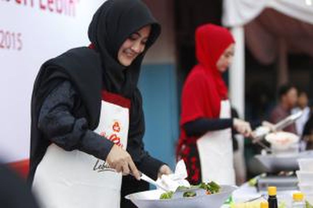 Umi Pipik (kiri) dan artis Annisa Trihapsari memasak mi goreng untuk berbuka puasa dalam acara 'Gerakan Ibu Memberi Lebih' di Panti Asuhan Muhammadiyah, Tanah Abang, Jakarta, Rabu (24/6/2015). Pada 5 Juli mendatang, kegiatan yang sama juga akan dilakukan secara serentak oleh para ibu di 30 kota di Pulau Jawa untuk memasak menu buka puasa kepada anak-anak panti asuhan.