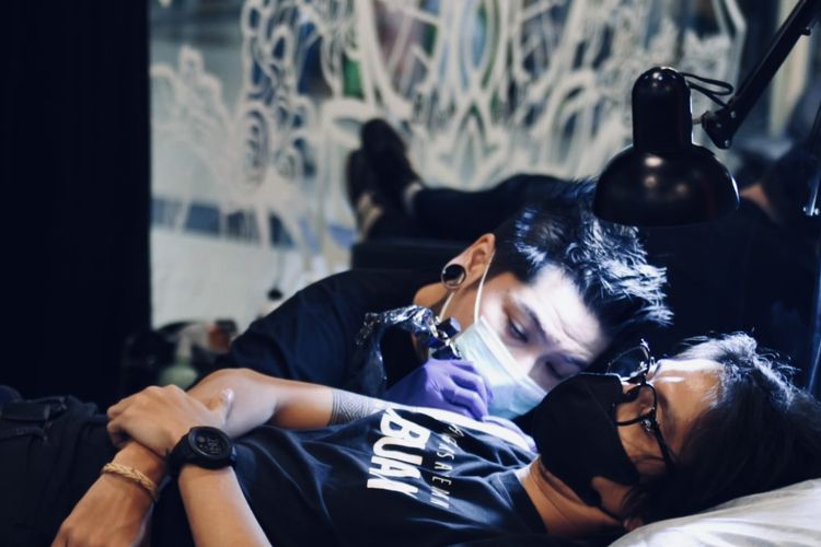 Arnaz Aditya Pratama tattoo artist sekaligus pemilik Sankara Tattoo Skinart studio saat menato kliennya di Pakuwon Trade Center (PTC) Surabaya.


