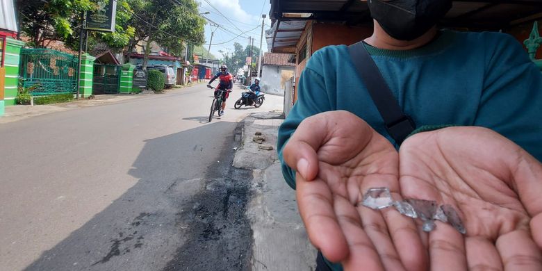 Warga menunjukkan serpihan botol sisa molotov yang digunakan kelompok motor untuk membakar kendaraan roda dua di Cimahi.