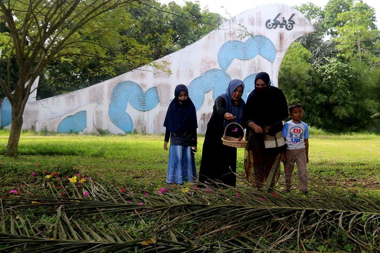 Peziarah mendoakan keluarga mereka yang menjadi korban gempa dan tsunami di pemakaman massal korban tsunami di Desa Siron, Kecamatan Ingin Jaya, Kabupaten Aceh Besar, Sabtu (26/12/2020). Setiap 26 Desember, memperingati tragedi gempa dan tsunami yang terjadi pada 2004 lalu, pemakaman tersebut selalu ramai didatangi warga untuk melakukan doa dan zikir. Di lokasi kuburan massal ini tercatat 46. 718 jiwa lebih dikebumikan korban tsunami.