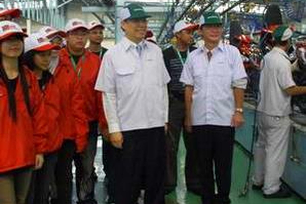 Presiden Direktur AHM Miki Yamamoto (kanan) dan Executive Vice President AHM Johannes Loman Ikiri) menjelaskan proses pembuatan motor