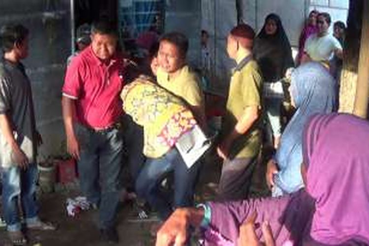 Suardi Daeng Tompo (34) tengah mengevakuasi jasad putrinya yang tewas tenggel di sungai setelah terpeleset di jembatan saat mencari ibunya di sawah Dusun Labbakkang, Desa Maradekaya, Kecamatan Bajeng, Kabupaten Gowa, Sulawesi Selatan. Rabu, (20/07/2016).