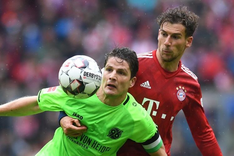 Leon Goretzka mencoba menahan laju Primin Schwegler pada pertandingan Bayern Muenchen vs Hannover 96 di Allianz Arena dalam lanjutan Liga Jerman, 4 Mei 2019. 