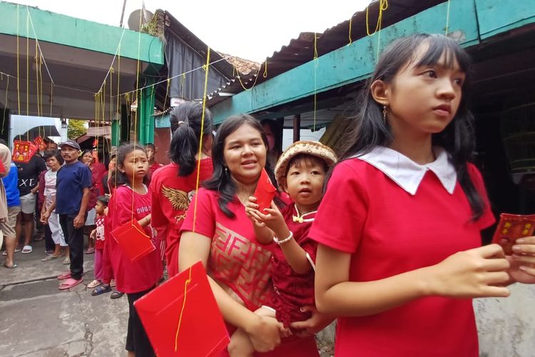Warga Kampung Pandekluwih, Purworejo, Jawa Tengah sedang merayakan Imlek dengan berebut angpao yang digantung di sepanjang jalan masuk kampung pada Sabtu (10/2/2024)