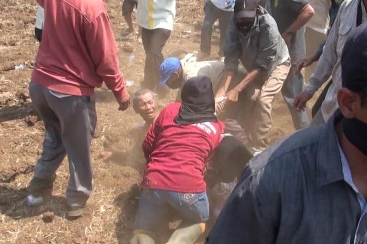 Seorang ibu di Kabupaten Takalar, Sulawesi Selatan berupaya menolong seorang petani renta yang tengah dikeroyok preman saat berusaha menghalangi pengolahan tebu diatas tanah sengketa antara para petani dengan pihak PTPN XIV. Senin, (27/10/2014).