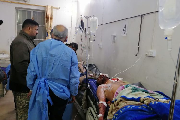 Staf medis memperhatikan anggota Hashed al-Shaabi, kelompok paramiliter Irak yang berafiliasi dengan Iran, setelah terkena serangan udara AS di Qaim, pada 29 Desember 2019.