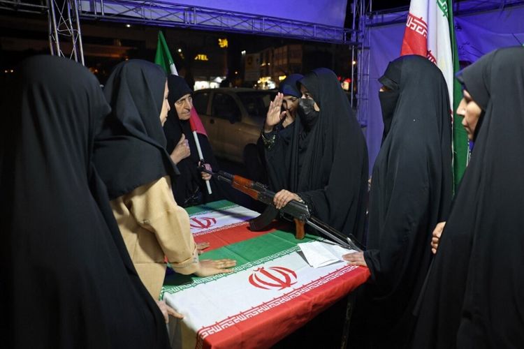Seorang personel militer Iran (C) mengedukasi perempuan tentang cara menggunakan senjata di sebuah stan di Lapangan Hafte Tir, Teheran pada 17 Mei 2026. 