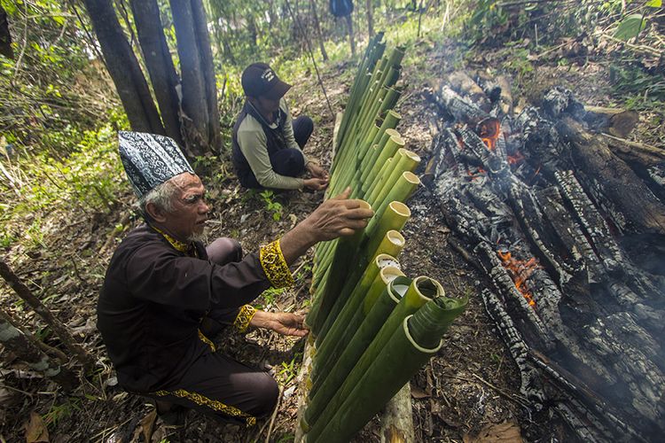 Foto dirilis Minggu (25/10/2020), memperlihatkan warga adat membakar kue lemang untuk ritual Seserahan Hutan di Desa Pa'au, Kecamatan Aranio, Kabupaten Banjar, Kalimantan Selatan. Warga Desa Pa'au merupakan suku Dayak Kayu Tangi yang sangat menghargai alam yaitu hutan di sekeliling mereka sehingga secara turun temurun setiap tahun mereka menggelar ritual Seserahan Hutan.