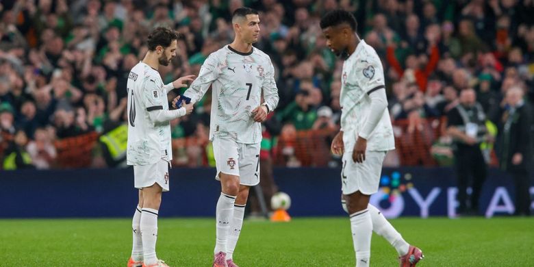 Penyerang timnas Portugal Cristiano Ronaldo menyerahkan ban kapten kepada Bernardo Silva (kiri) sebelum ia meninggalkan lapangan setelah menerima kartu merah langsung pada laga kualifikasi Grup F Piala Dunia 2026 antara Irlandia dan Portugal di Stadion Aviva di Dublin pada 13 November 2025.