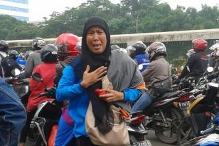 Seorang perempuan tenaga honorer yang melakukan aksi di depan Gedung DPR, Jumat (14/3/2014), berdiri di tengah kemacetan sambil menangis.