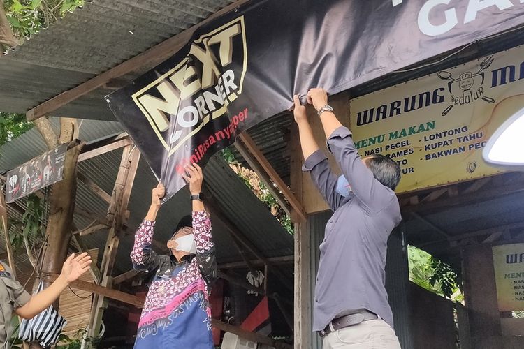 Petugas menurunkan banner dan spanduk rokok di sebuah warung di Kabupaten Kulon Progo, Daerah Istimewa Yogyakarta. Penjabat Bupati Kulon Progo, Tri Saktiyana memimpin penertiban ini, diikuti petugas Satpol PP dan Dinas Kesehatan.