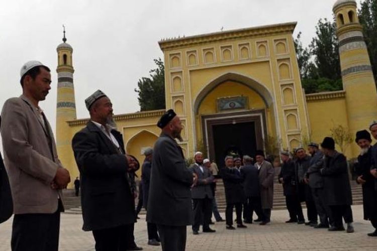 Warga Suku Uighur berkumpul usai menjalankan shalat di Masjid Id Kah di Kashgar, Xinjiang, China bagian barat, 19 April 2015. Pihak berwenang China telah membatasi ekspresi agama di Xinjiang, yang telah memicu perlawanan.