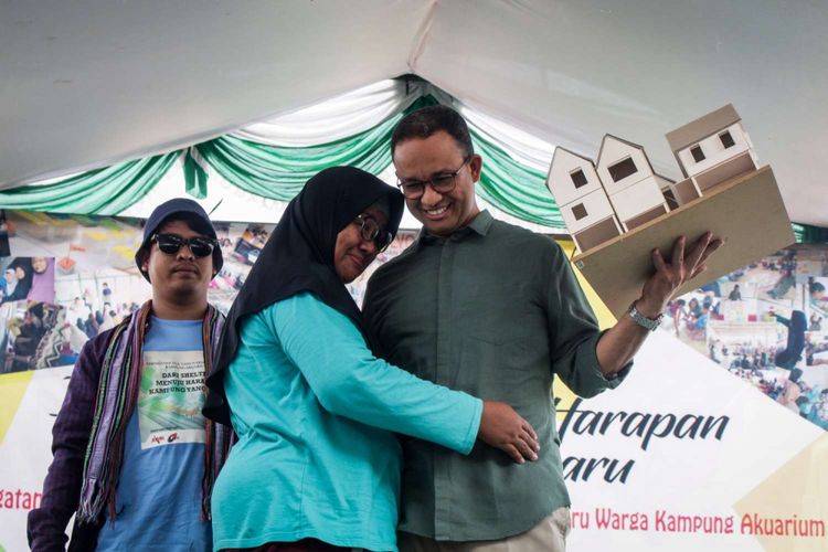 Gubernur DKI Jakarta Anies Baswedan (kanan) saat menerima simbolis desain rumah pada peringatan dua tahun penggusuran di Kampung Akuarium , Penjaringan, Jakarta, Sabtu (14/4/2018). Peringatan yang  bertajuk Dari Shelter Menuju Harapan Kampung yang Baru tersebut menampilkan pertunjukan warga kampung seperti musik dan tarian daerah.