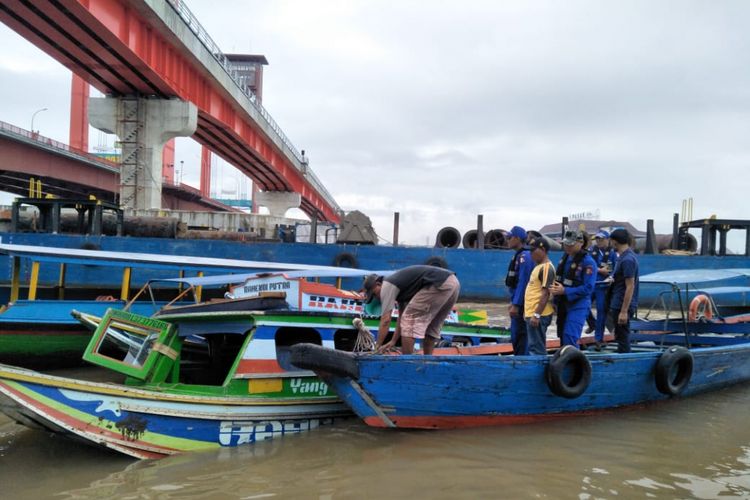 Petugas melakukan evakuasi terhadap speedboat di sungai Musi yang mengalami tabrakan 