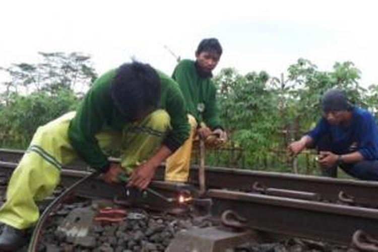 Petugas PT KA memperbaiki rel yang rusak di Kota Malang, Rabu (18/3/2015). Rel ini sangat berbahaya untuk dilalui kereta api. 