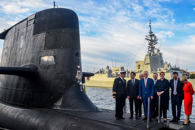 Presiden Perancis Emmanuel Macron (dua dari kiri) dan mantan Perdana Menteri Australi Malcolm Turnbull (tengah) di atas kapal selam HMAS Waller milik Angkatan Laut Australia, di Sydney, pada Mei 2018.