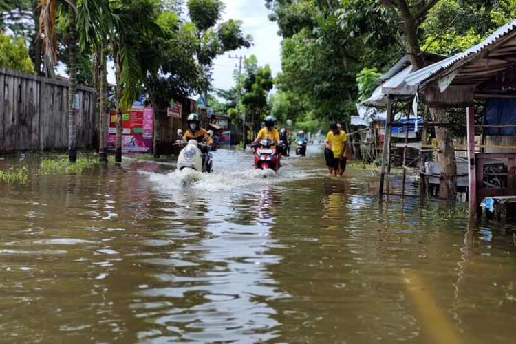 Sejumlah pengendara roda dua menerobos banjir yang menggenangi ruas Jalan Bangau Sakti di Kelurahan Simpang Baru, Kecamatan Bina Widya, Kota Pekanbaru, Riau, Kamis (22/4/2021).