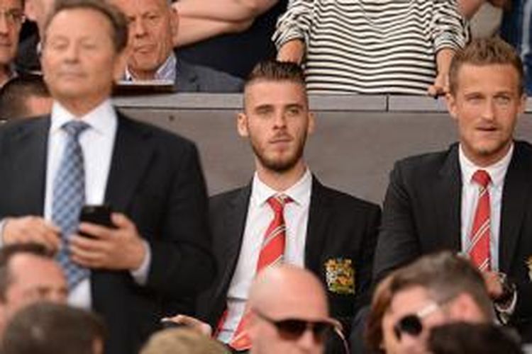 David De Gea duduk di tribun penonton Stadion Old Trafford saat Manchester United hadapi Tottenham Hotspur, Sabtu (8/8/2015). 