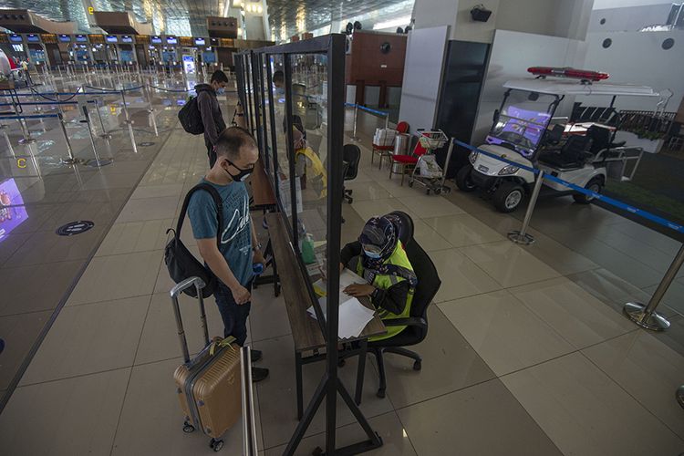 Calon penumpang menyerahkan dokumen hasil tes rapid negatif COVID-19 kepada petugas di Terminal 3 Bandara Internasional Soekarno-Hatta, Tangerang, Banten, Kamis (9/7/2020). Meski penerbangan telah kembali dibuka dengan persyaratan  seperti penumpang harus dengan memiliki hasil rapid atau PCR test negatif COVID-19, suasana di Bandara Soekarno Hatta masih terpantau sepi.