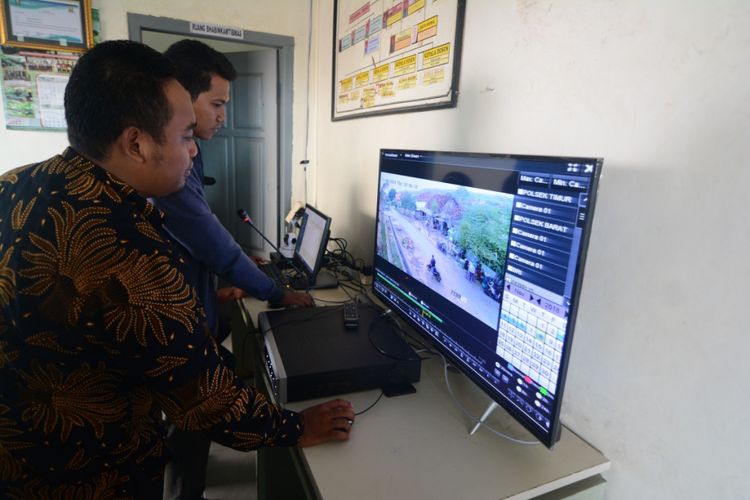 Kepala Desa Waru Barat, Kecamatan Waru, Kabupaten Pamekasan, Abdussalam Ramli memantau kondisi desanya melalui layar televisi. Di desa ini terpasang 32 kamera dan pengeras suara untuk bisa berkomunikasi dengan warga.