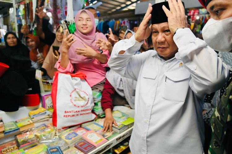 Menhan Prabowo Subianto saat menjajal peci yang baru dibelinya di Pasar Petanahan di Kabupaten Kebumen, Provinsi Jawa Tengah, Kamis (9/3/2023).