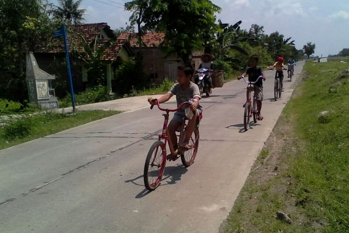 Anak - anak bermain sepeda di ruas jalan Karanganyar - Dempet,  Kabupaten Demak Jateng,  yang dibangun Pemkab Demak dengan cor beton, Sabtu (25/3/2017).