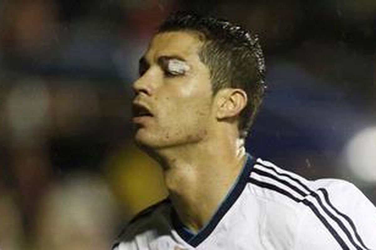Bintang Real Madrid, Cristiano Ronaldo, merayakan gol pembuka yang dicetaknya ke gawang Levante, Minggu (11/11/2012). Terlihat pelipis Ronaldo luka akibat sikutan David Navarro.