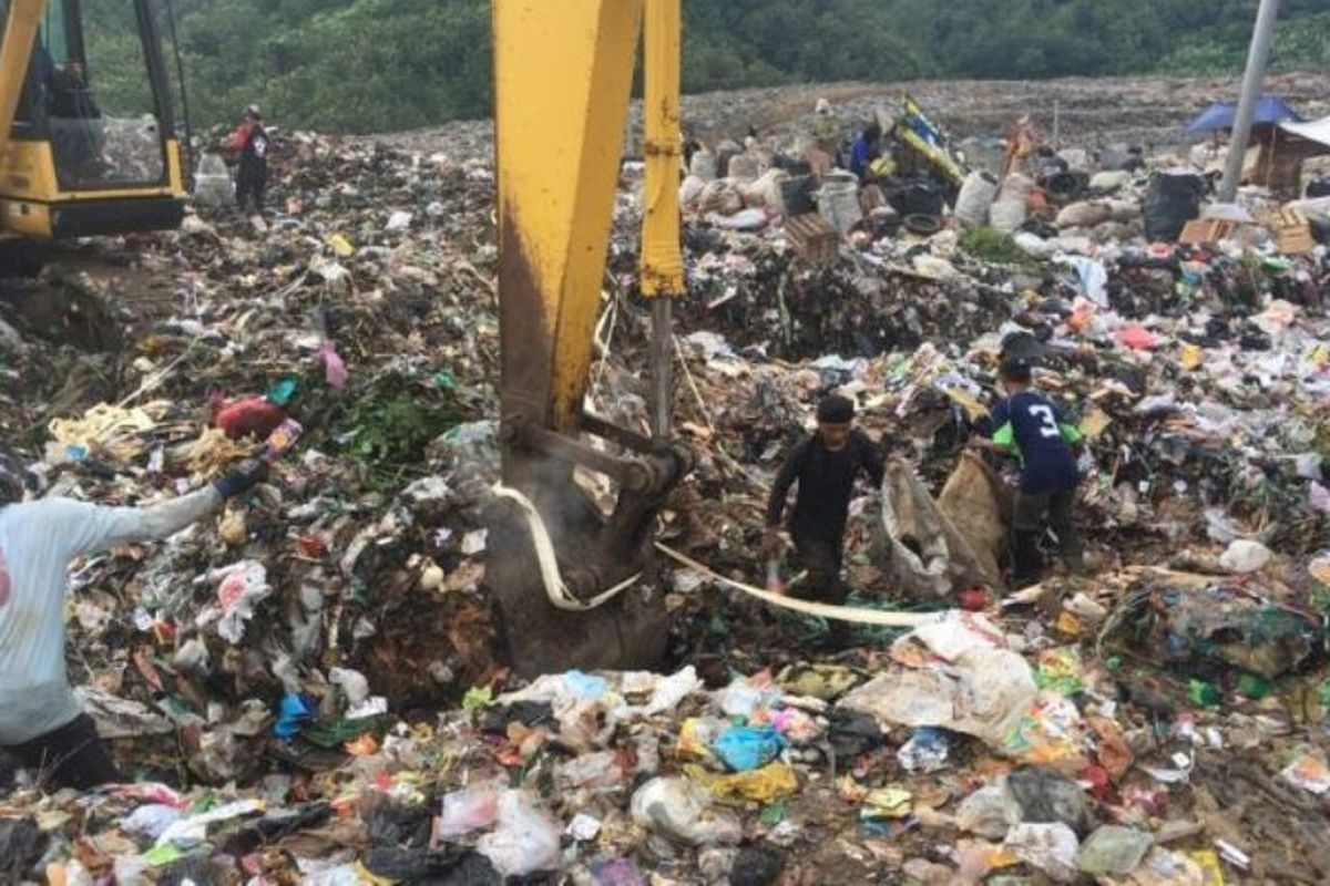 Para pemulung sedang memilih sampah plastik di sebuah TPA.