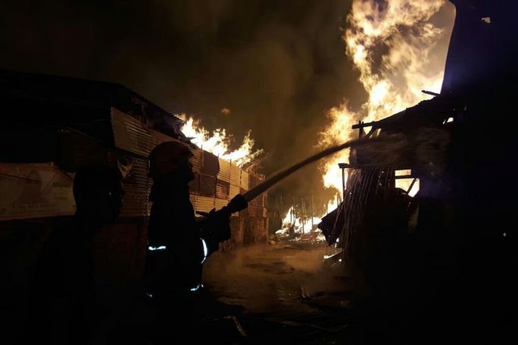 Petugas tengah melakukan pemadaman api yang membumbung tinggi membakarlahan Kosong (digunakan untuk penyimpanan kayu bekas), 40 Jongko Kayu dan 30 Rumah warga (non-permanen) di Jalan Babakan Ciparay, Gang Satatasariska RT 08 /04, Kelurahan Sukahaji, Kecamatan Babakan Ciparay, Kota Bandung, Jawa Barat.