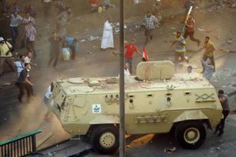 Pendukung Presiden Mesir terguling Muhammad Mursi, melempari kendaraan militer di Kantor Kementerian Keuangan di Kairo, Mesir, 14 Agustus 2013.