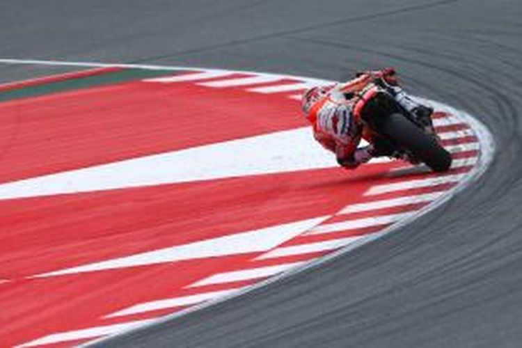 Pebalap Repsol Honda asal Spanyol, Marc Marquez, saat beraksi dengan melintasi kerb.