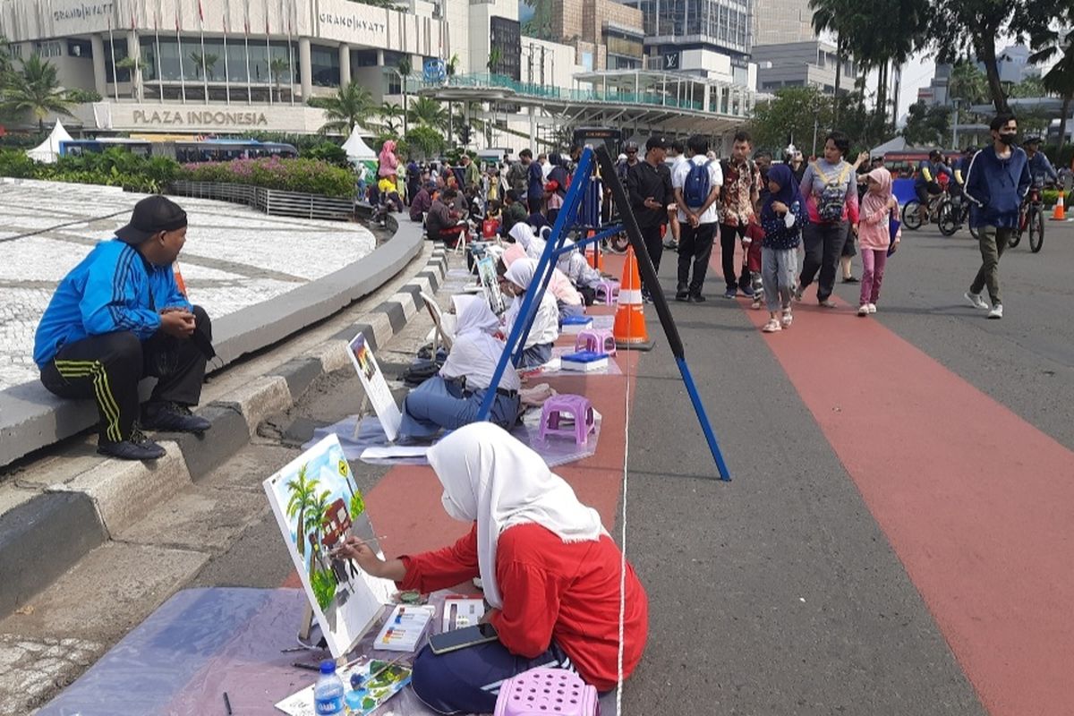 Ratusan pelukis berkumpul saat car free day (CFD) di Bundaran Hotel Indonesia (HI), Jakarta Pusat, Minggu (18/9/2022) pagi.  Mereka unjuk kebolehan untuk memeriahkan Hari Lalu Lintas Ke-67 Bhayangkara.