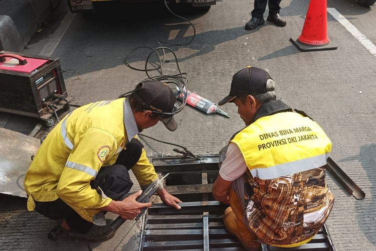Petugas Dinas Bina Marga DKI Jakarta saat membuat penutup lubang gorong-gorong baru di underpass Mampang, Jakarta Selatan, Jumat (11/8/2023).