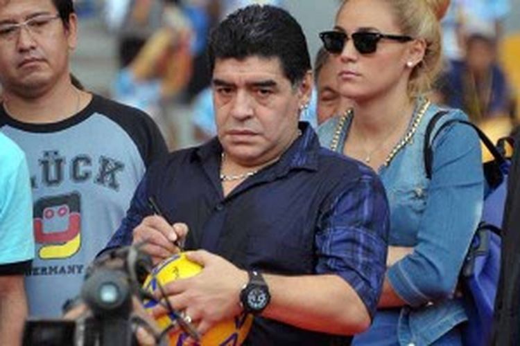 Legenda sepak bola Argentina, Diego Maradona (tengah), membubuhkan tanda tangan di sebuah bola sebelum menendangnya dalam sesi coaching clinic di Gelora Bung Karno Jakarta, 29 Juni 2013.