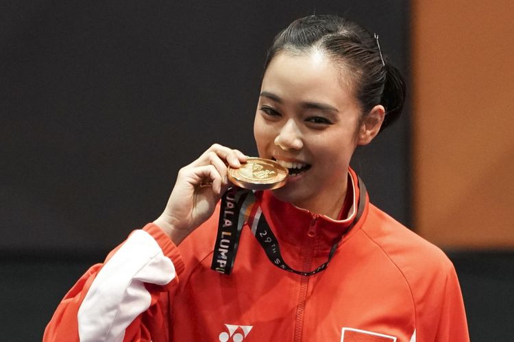 Atlet wushu Indonesia Lindswell Kwok menggigit medali ketika upacara penyerahan medali wushu nomor Taijijian putri di KLCC, Kuala Lumpur, Malaysia, Senin (21/8/2017). Lindswell mempersembahkan emas kelima untuk Indonesia dengan mengumpulkan nilai 9.68.