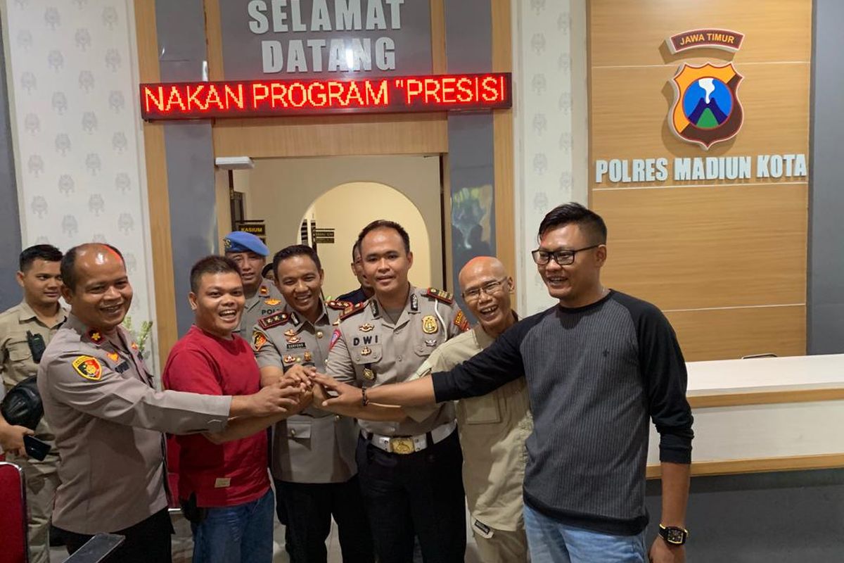 DAMAI—Kapolres Madiun Kota, AKBP Suryono menyatukan tangan Kasat Lantas, AKP Dwi Jatmiko (tiga dari kanan) dengan wartawan Jatim Pos, Jumali (dua dari kiri) sebagai tanda perdamaian antara keduanya di Mapolres Madiun Kota, Selasa (23/8/2022). 