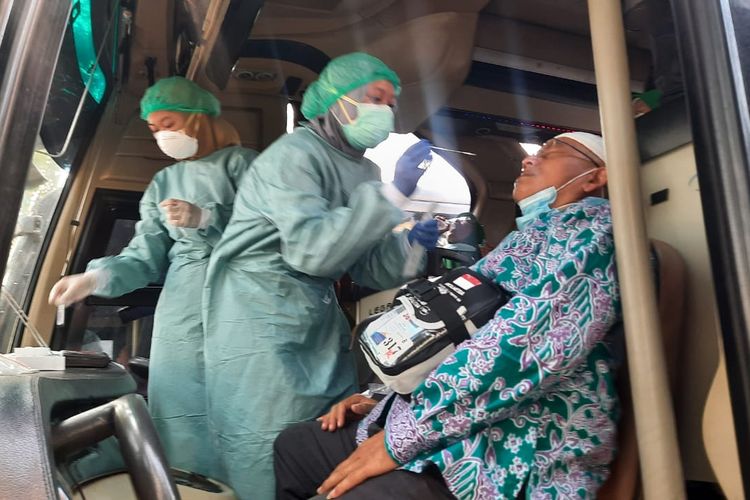 Petugas Dinkes Depok tengah melakukan tes swab antigen kepada salah satu jamaah haji asal Depok di dalam bus rombongan jamaah haji di Balai Kota, Depok pada Kamis (21/7/2022).